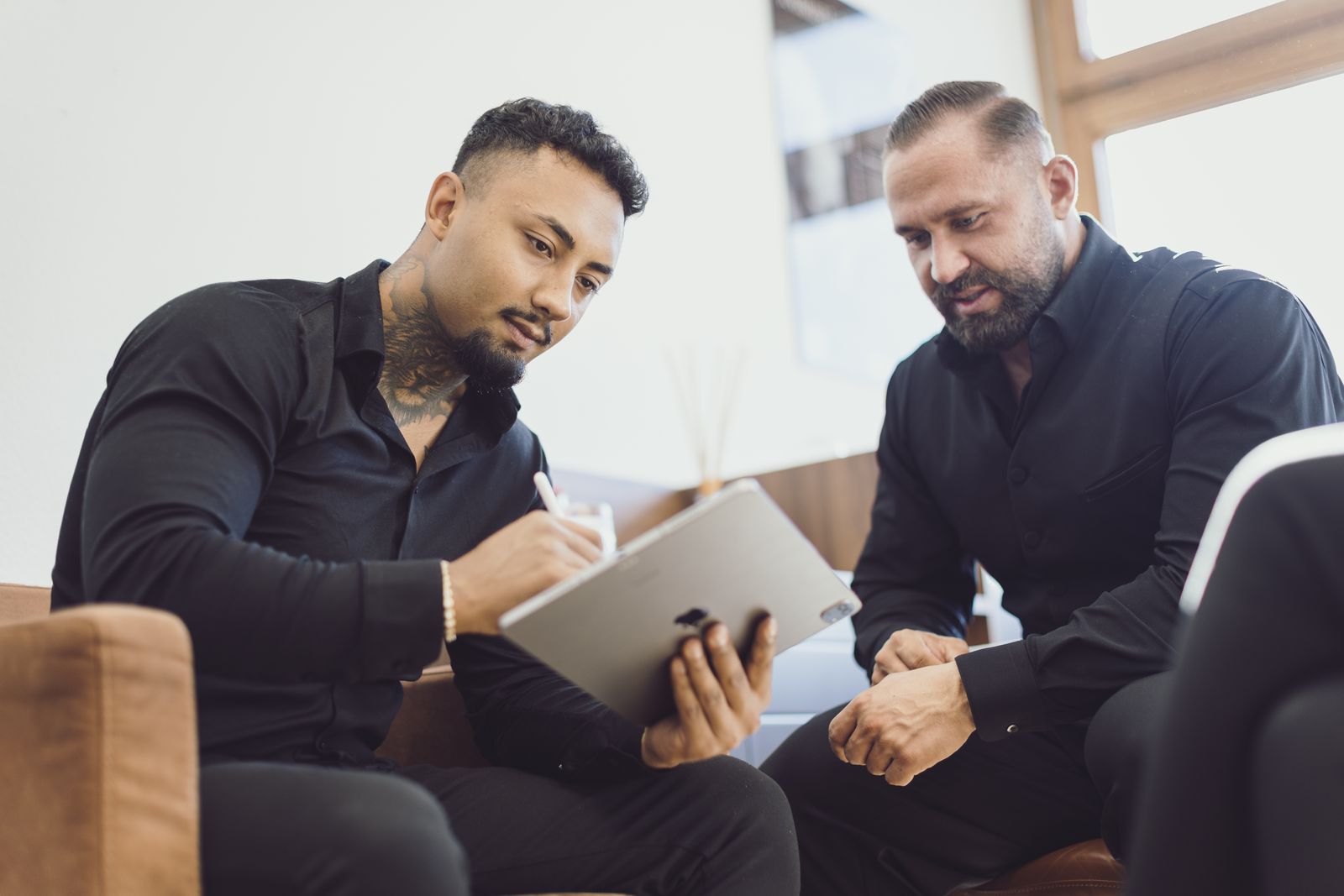 Zwei SALESCO Mitarbeiter besprechen gemeinsam Unterlagen im Büro in Stuttgart